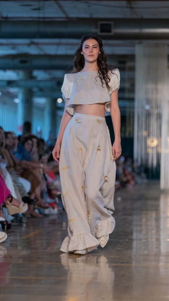 Pantalón alto con holanes y caída suelta y blusa corta con hombreras de Bless. 